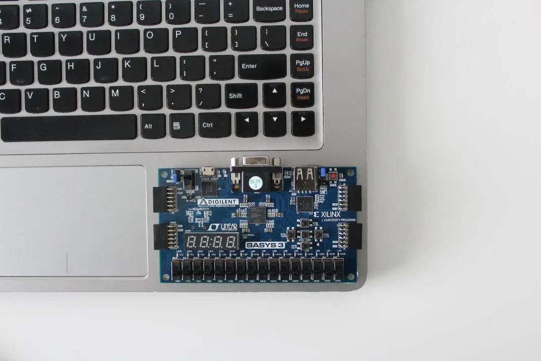 Placa de desarrollo electrónica junto al teclado de un portátil